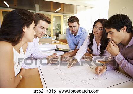 Stock Photography - Group Of Architects Discussing Plans In Modern Office. Fotosearch