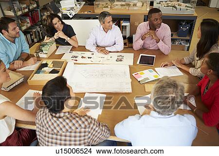 Picture - Group Of Architects Sitting Around Table Having Meeting. Fotosearch