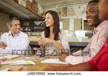 Group Of Architects Sitting Around Table Having Meeting View Large Photo Image Stock Image - Group Of Architects Sitting Around Table Having Meeting. Fotosearch
