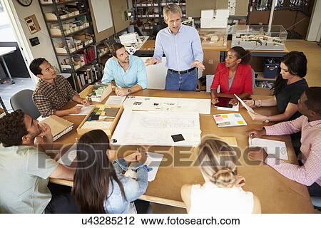 Group Of Architects Sitting Around Table Having Meeting View Large Photo Image Stock Image - Group Of Architects Sitting Around Table Having Meeting. Fotosearch