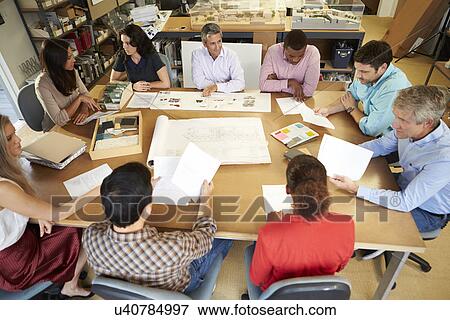 Group Of Architects Sitting Around Table Having Meeting View Large Photo Image Stock Photo - Group Of Architects Sitting Around Table Having Meeting. Fotosearch