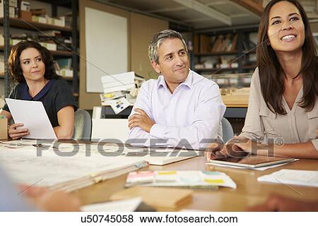 Group Of Architects Sitting Around Table Having Meeting View Large Photo Image Stock Photo - Group Of Architects Sitting Around Table Having Meeting. Fotosearch