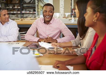 Group Of Architects Sitting Around Table Having Meeting View Large Photo Image Stock Photo - Group Of Architects Sitting Around Table Having Meeting. Fotosearch