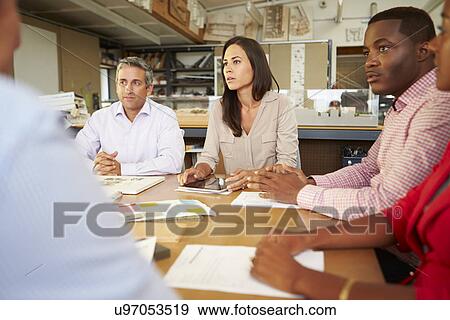 Group Of Architects Sitting Around Table Having Meeting View Large Photo Image Stock Photo - Group Of Architects Sitting Around Table Having Meeting. Fotosearch