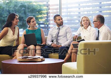 Group Of Businesspeople Having Meeting In Office Lobby View Large Photo Image Stock Photograph - Group Of Businesspeople Having Meeting In Office Lobby. Fotosearch