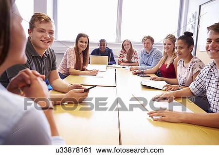 Group Of College Students Sitting At Table Having Discussion View Large Photo Image Stock Image - Group Of College Students Sitting At Table Having Discussion. Fotosearch