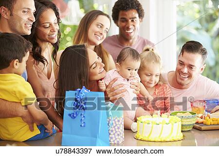 Stock Photo - Group Of Families Celebrating Child's First Birthday At Home. Fotosearch