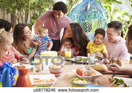 Stock Photograph - Group Of Families Celebrating Child's Birthday At Home. Fotosearch
