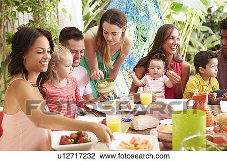 Group Of Families Enjoying Outdoor Meal At Home View Large Photo Image Stock Image - Group Of Families Enjoying Outdoor Meal At Home. Fotosearch