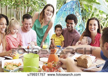 Stock Photo - Group Of Families Enjoying Outdoor Meal At Home. Fotosearch