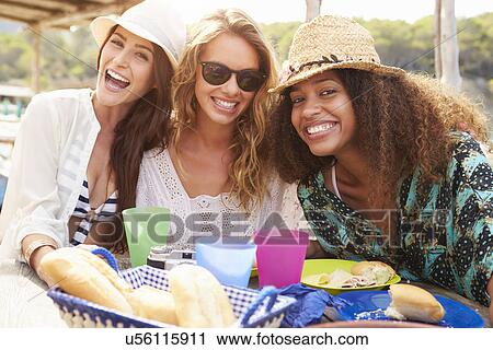 Stock Image - Group Of Female Friends Enjoying Lunch Outdoors. Fotosearch