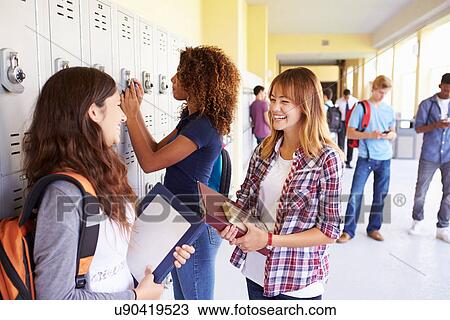 Stock Image - Group Of Female High School Students Talking By Lockers. Fotosearch