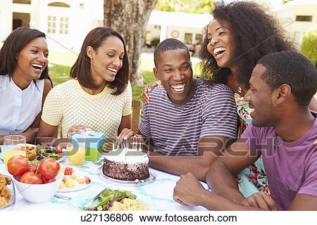 Stock Photograph - Group Of Friends Celebrating Birthday At Home. Fotosearch