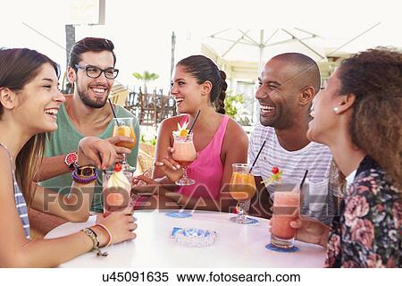 Stock Photography - Group Of Friends Drinking Cocktails At Outdoor Bar. Fotosearch