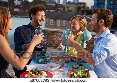 Group Of Friends Eating Meal On Rooftop Terrace View Large Photo Image Stock Image - Group Of Friends Eating Meal On Rooftop Terrace. Fotosearch