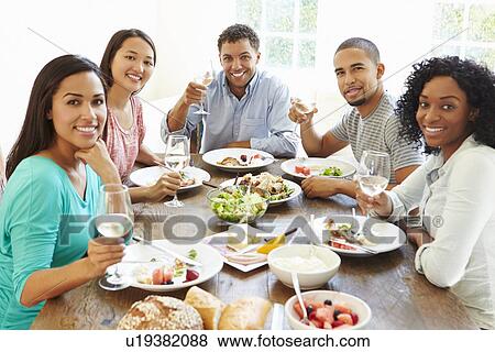 Group Of Friends Enjoying Meal At Home Together View Large Photo Image Stock Photo - Group Of Friends Enjoying Meal At Home Together. Fotosearch