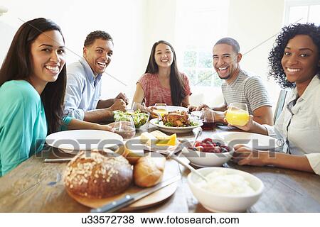 Group Of Friends Enjoying Meal At Home Together View Large Photo Image Stock Photo - Group Of Friends Enjoying Meal At Home Together. Fotosearch