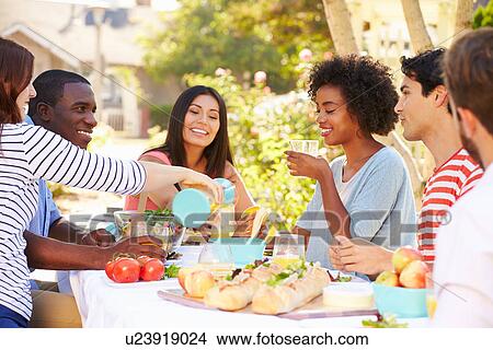Group Of Friends Enjoying Meal At Outdoor Party In Back Yard View Large Photo Image Picture - Group Of Friends Enjoying Meal At Outdoor Party In Back Yard. Fotosearch