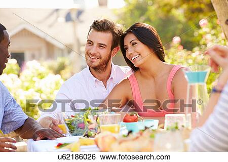 Group Of Friends Enjoying Meal At Outdoor Party In Back Yard View Large Photo Image Stock Photograph - Group Of Friends Enjoying Meal At Outdoor Party In Back Yard. Fotosearch