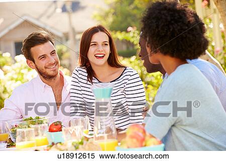 Stock Photography - Group Of Friends Enjoying Meal At Outdoor Party In Back Yard. Fotosearch