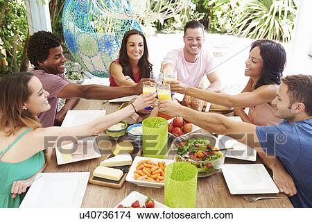 Group Of Friends Enjoying Meal Outdoors At Home View Large Photo Image Picture - Group Of Friends Enjoying Meal Outdoors At Home. Fotosearch