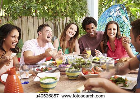 Group Of Friends Enjoying Meal Outdoors At Home View Large Photo Image Stock Photo - Group Of Friends Enjoying Meal Outdoors At Home. Fotosearch