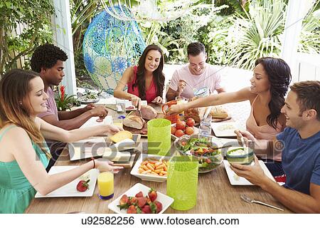 Group Of Friends Enjoying Meal Outdoors At Home View Large Photo Image Stock Photograph - Group Of Friends Enjoying Meal Outdoors At Home. Fotosearch