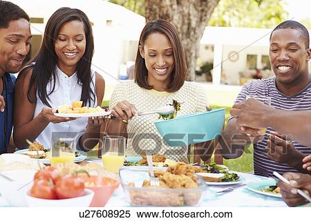 Stock Photography - Group Of Friends Enjoying Outdoor Meal At Home. Fotosearch