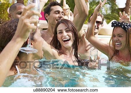 Picture - Group Of Friends Having Party In Pool Drinking Champagne. Fotosearch