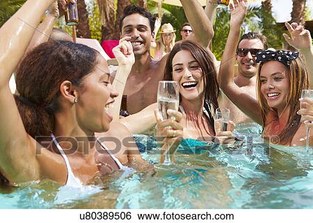 Stock Photograph - Group Of Friends Having Party In Pool Drinking Champagne. Fotosearch