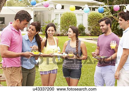 Stock Image - Group Of Friends Having Party In Backyard At Home. Fotosearch