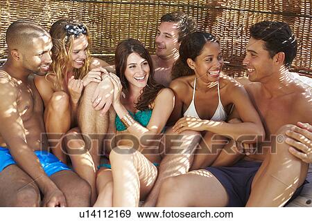 Group Of Friends In Swimwear Relaxing Outdoors Together View Large Photo Image Stock Photo - Group Of Friends In Swimwear Relaxing Outdoors Together. Fotosearch