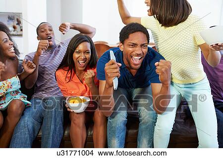 Group Of Friends Sitting On Sofa Watching TV Together View Large Photo Image Picture - Group Of Friends Sitting On Sofa Watching TV Together. Fotosearch