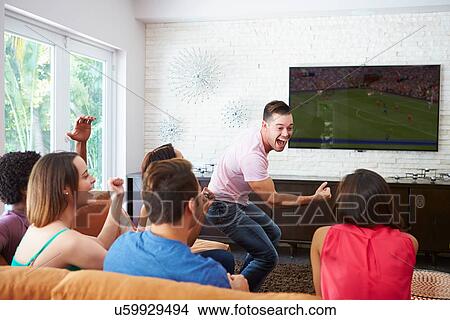 Group Of Friends Sitting On Sofa Watching Soccer Together View Large Photo Image Picture - Group Of Friends Sitting On Sofa Watching Soccer Together. Fotosearch