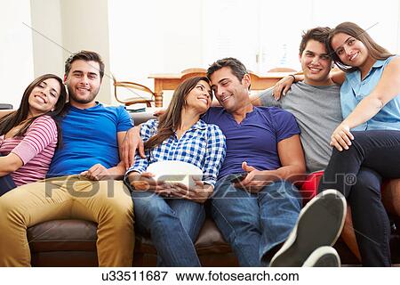 Stock Photo - Group Of Friends Sitting On Sofa Watching TV Together. Fotosearch