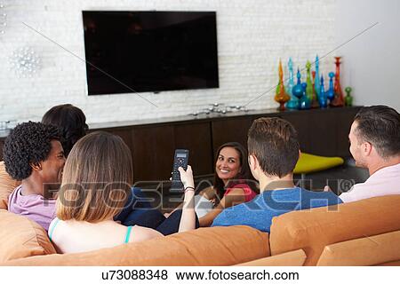 Stock Photo - Group Of Friends Sitting On Sofa Watching TV Together. Fotosearch