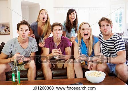 Group Of Friends Sitting On Sofa Watching Sport Together View Large Photo Image Stock Photo - Group Of Friends Sitting On Sofa Watching Sport Together. Fotosearch
