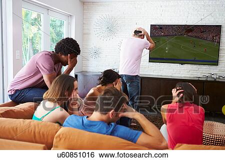 Group Of Friends Sitting On Sofa Watching Soccer Together View Large Photo Image Stock Photograph - Group Of Friends Sitting On Sofa Watching Soccer Together. Fotosearch