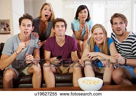 Group Of Friends Sitting On Sofa Watching TV Together View Large Photo Image Stock Photography - Group Of Friends Sitting On Sofa Watching TV Together. Fotosearch