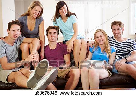 Stock Photography - Group Of Friends Sitting On Sofa Watching TV Together. Fotosearch