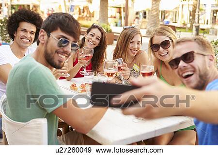 Stock Photo - Group Of Friends Taking Selfie During Lunch Outdoors. Fotosearch