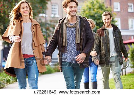 Stock Photo - Group Of Friends Walking Through City Park Together. Fotosearch