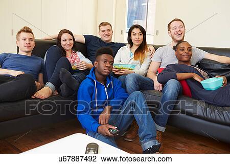 Stock Image - Group Of Friends Watching Television At Home Together. Fotosearch