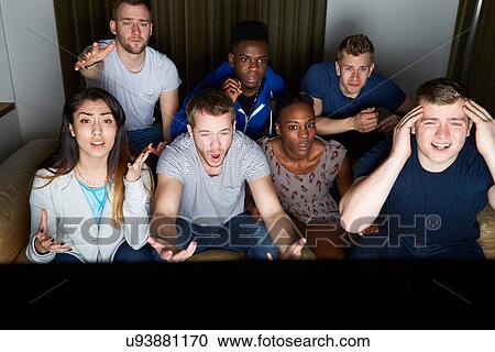 Stock Image - Group Of Friends Watching Television At Home Together. Fotosearch