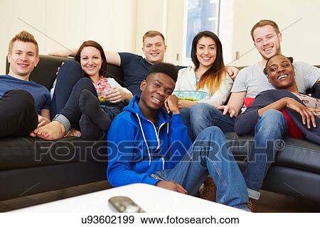 Stock Photo - Group Of Friends Watching Television At Home Together. Fotosearch