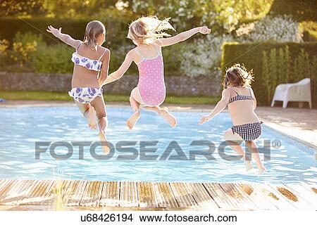 Picture - Group Of Girls Jumping Into Outdoor Swimming Pool. Fotosearch