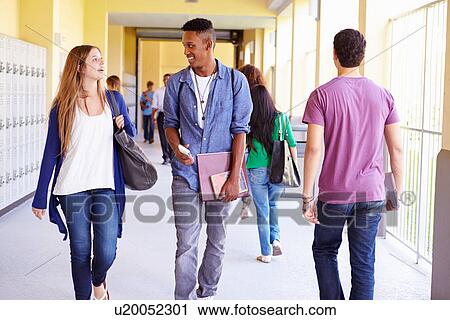 Stock Image - Group Of High School Students Walking Along Hallway. Fotosearch