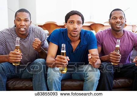 Group Of Men Sitting On Sofa Watching TV Together View Large Photo Image Stock Image - Group Of Men Sitting On Sofa Watching TV Together. Fotosearch