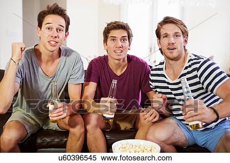 Group Of Men Sitting On Sofa Watching Sport Together View Large Photo Image Stock Photography - Group Of Men Sitting On Sofa Watching Sport Together. Fotosearch