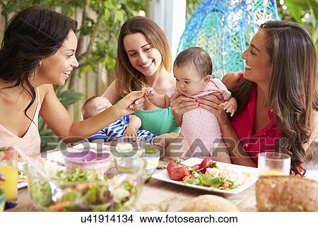 Picture - Group Of Mothers With Babies Enjoying Outdoor Meal At Home. Fotosearch